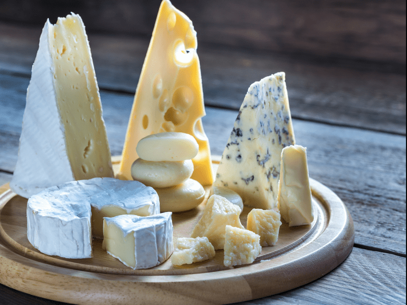 a plate of cheese on a wood surface